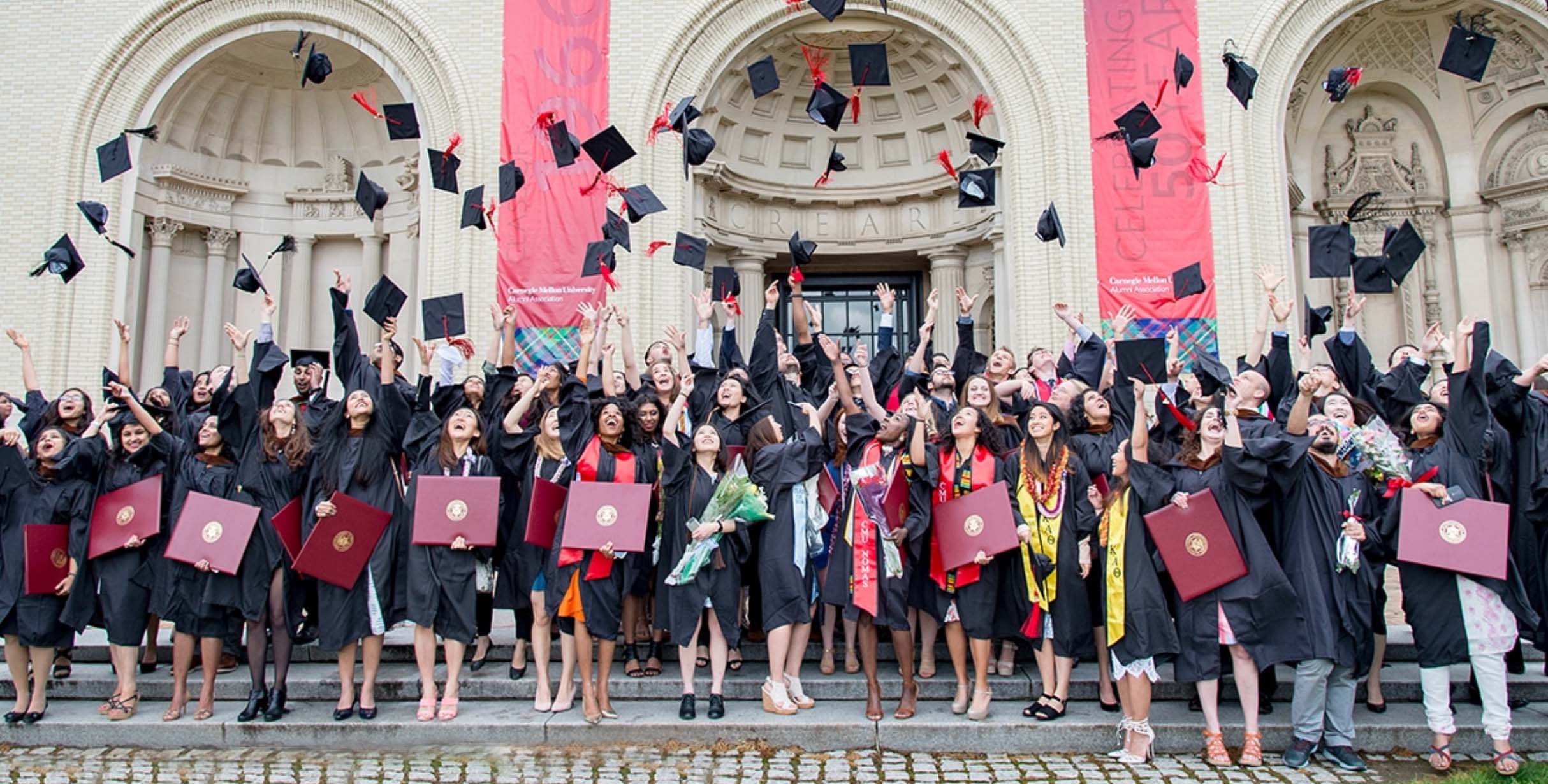 Students toss their graduation caps in the air on CMU's campus