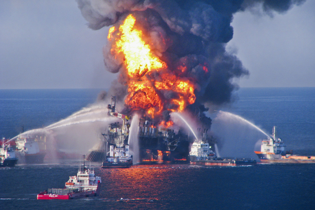 Fire boat response crews battle the blazing remnants of the oil rig Deepwater Horizon off the Louisiana coast in the Gulf of Mexico, April 21, 2010. A Coast Guard MH-65C dolphin rescue helicopter and crew document the fire aboard the mobile drilling unit Deepwater Horizon, while searching for survivors. Multiple Coast Guard helicopters, planes and cutters responded to rescue the Deepwater Horizon's 126 person crew. U.S. Coast Guard photo