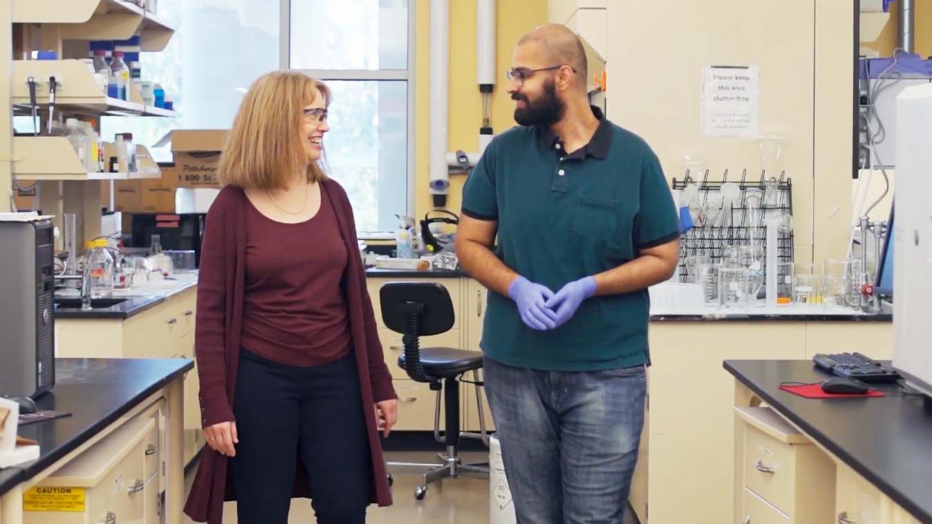 Anne Robinson walks through lab with student at CMU
