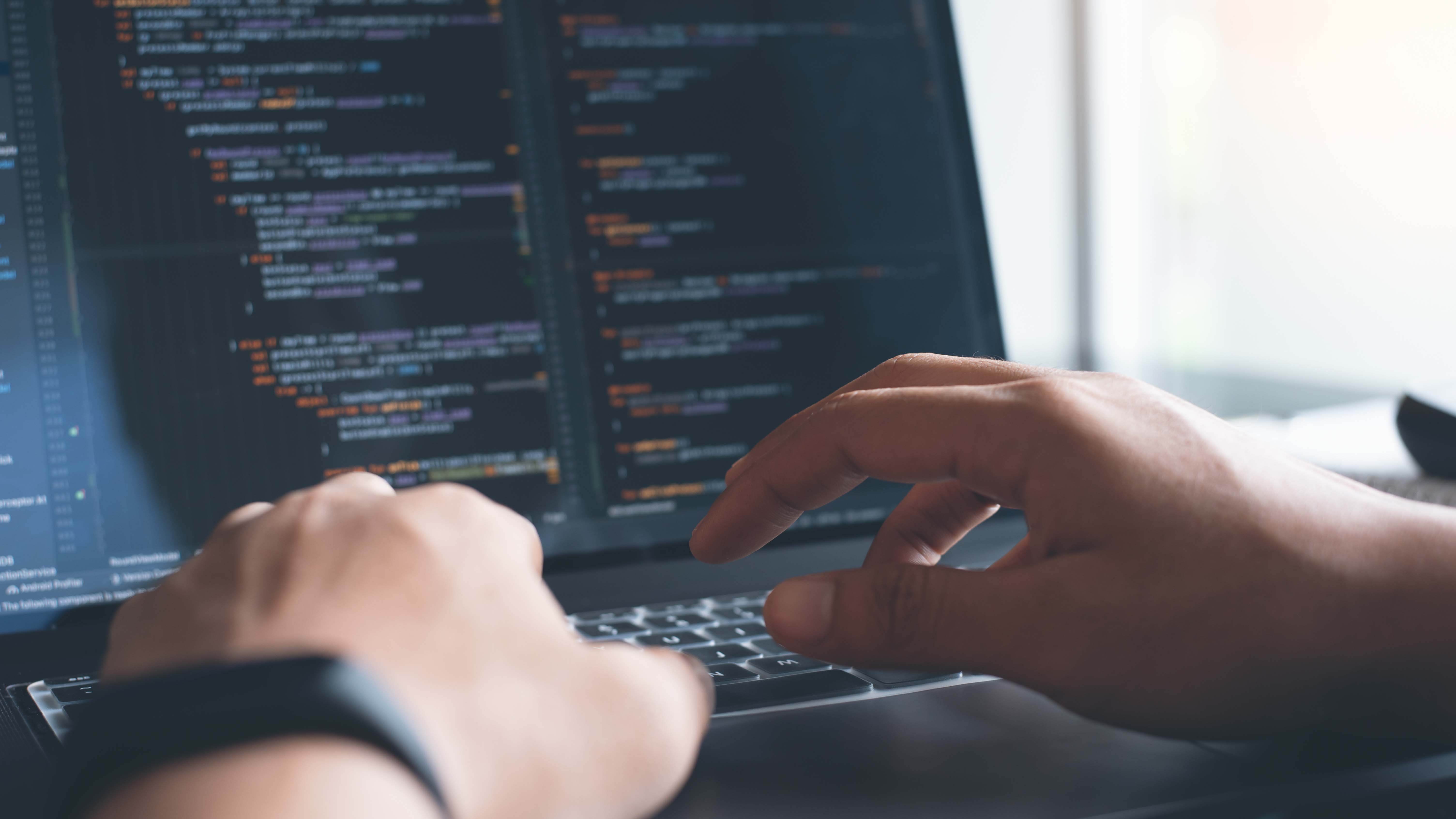 stock image of a person coding - hands on computer