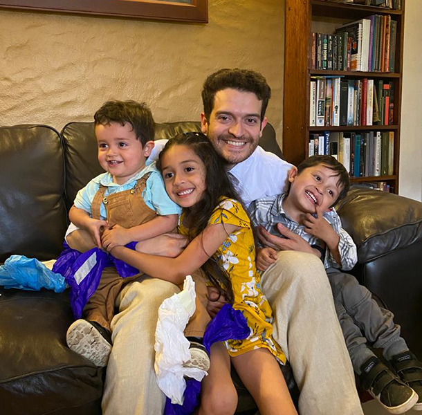 Hector Perez sitting on a couch with his three children