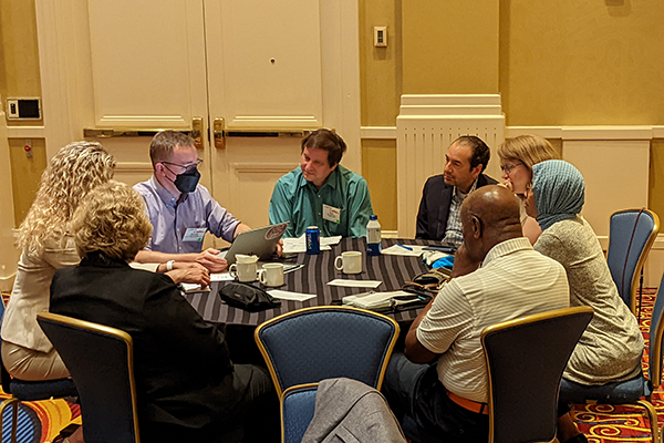 Anne Robinson sits at a table with other workshop participants