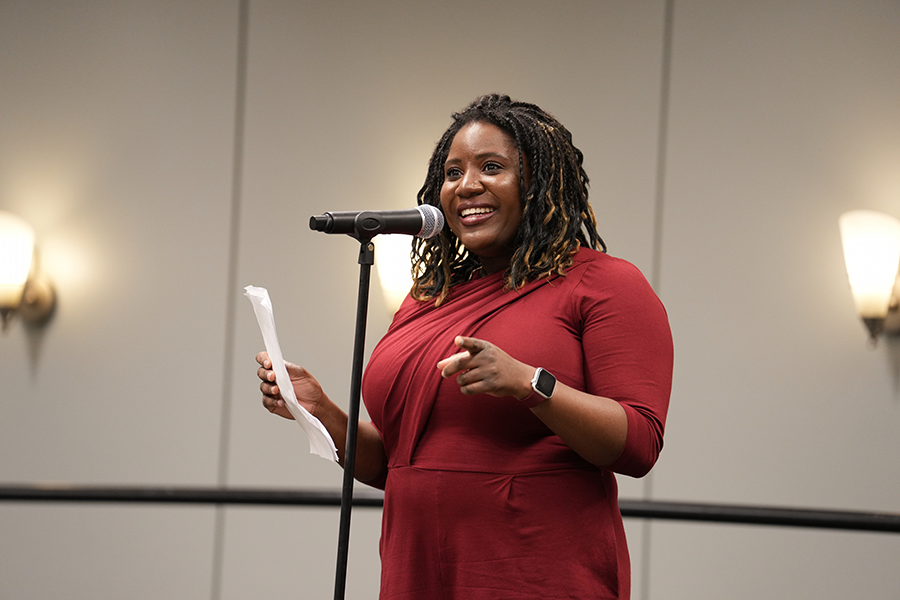 Liz Wayne smiling while standing in front of a microphone