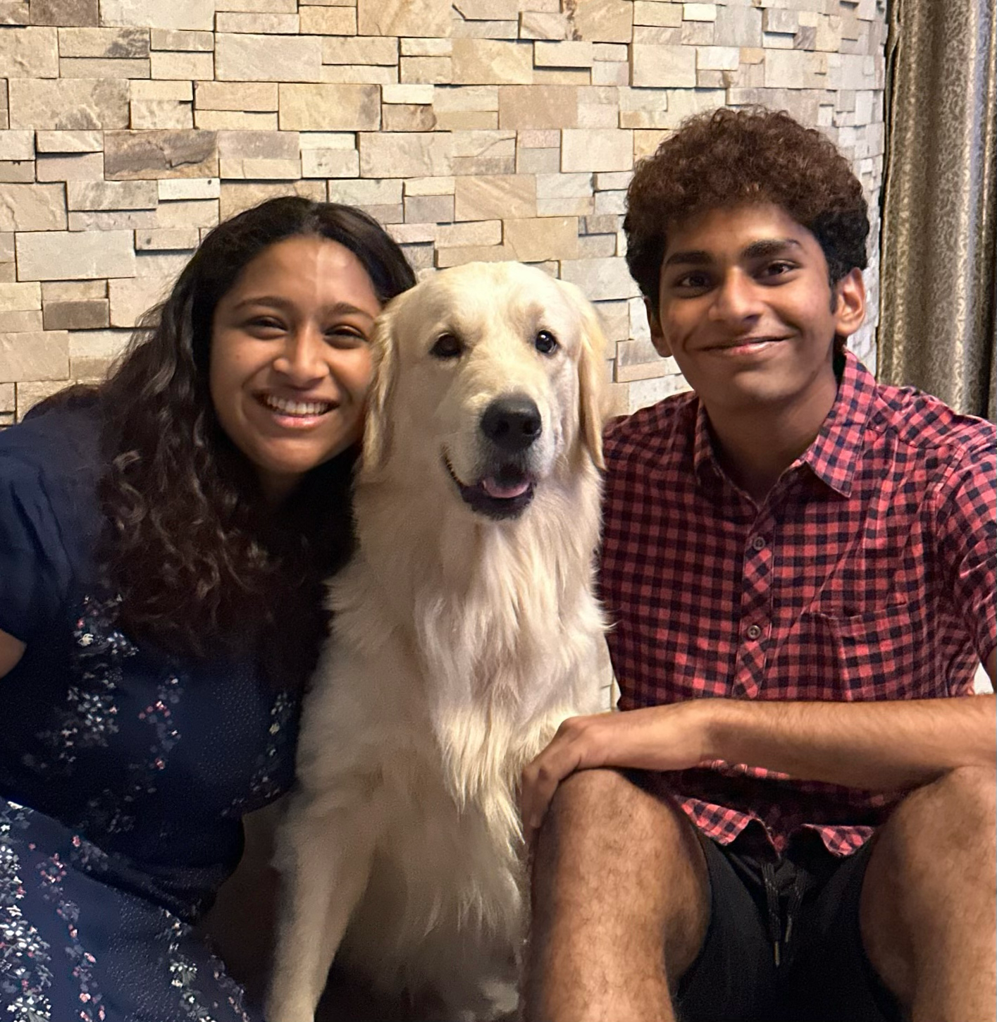 Ashni Arun sitting next to her dog and her brother.
