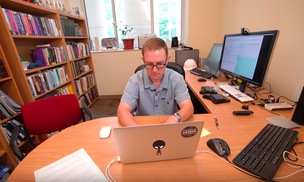 John Kitchin typing on his laptop at his desk.