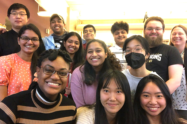 A group of 13 young adults pose for a photo.