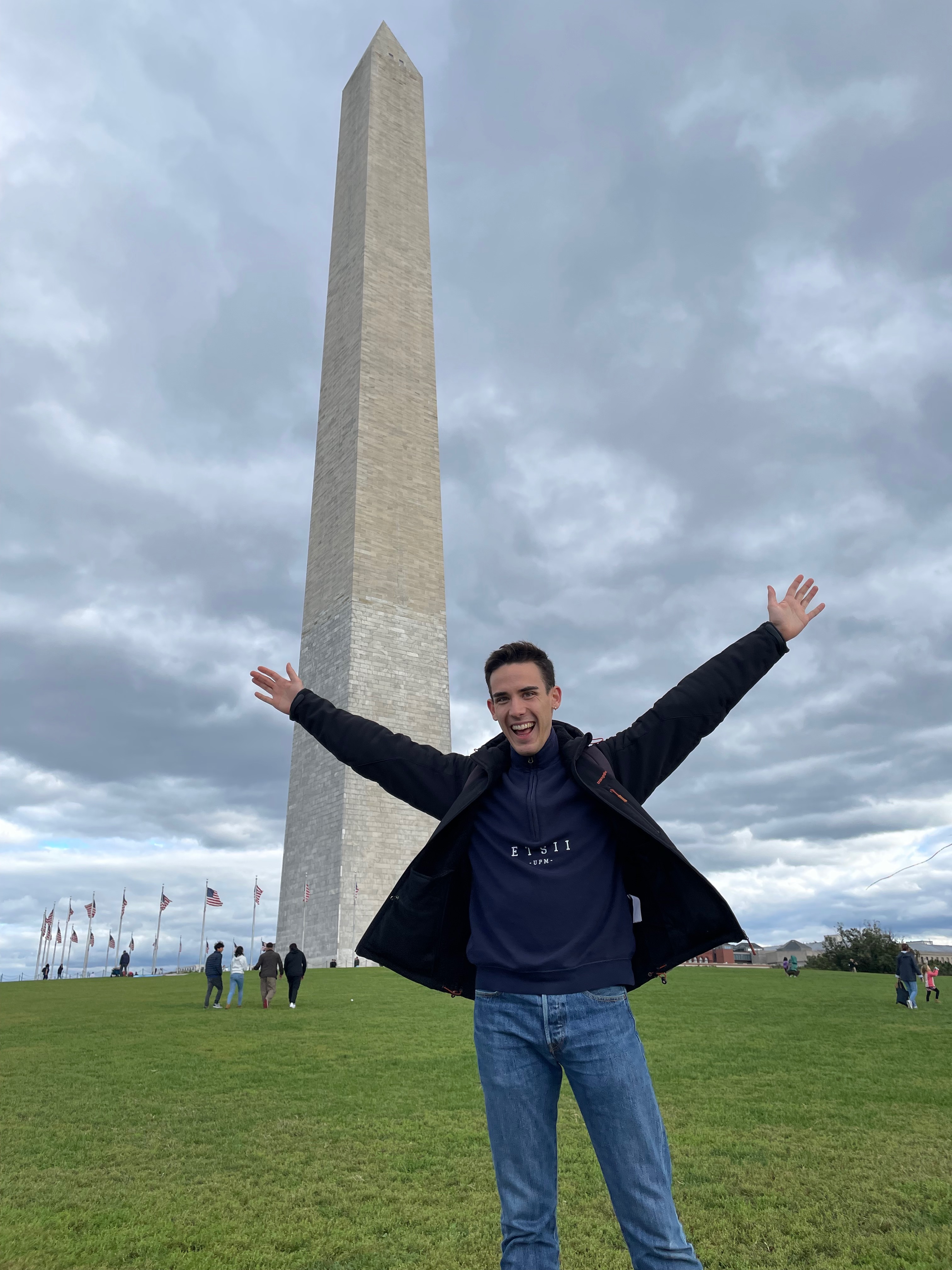 Victor Soria standing with arms raised, in front of the Washington Monument